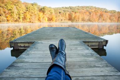 Personal Perspective Woman Resting On Dock Enjoying Fall View